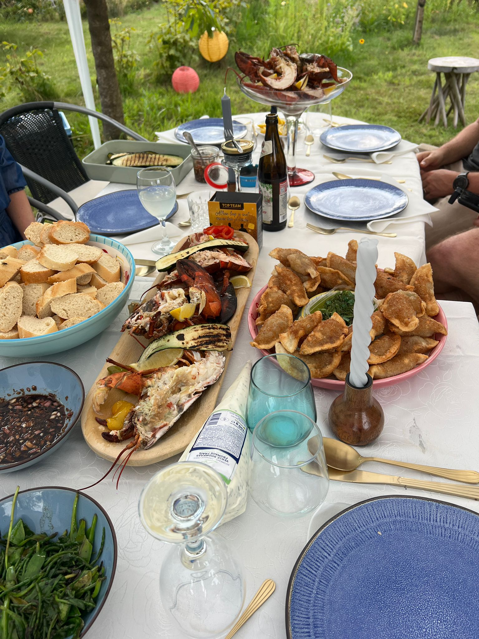 Kreeft, brood, gyoza's en wijn op tafel